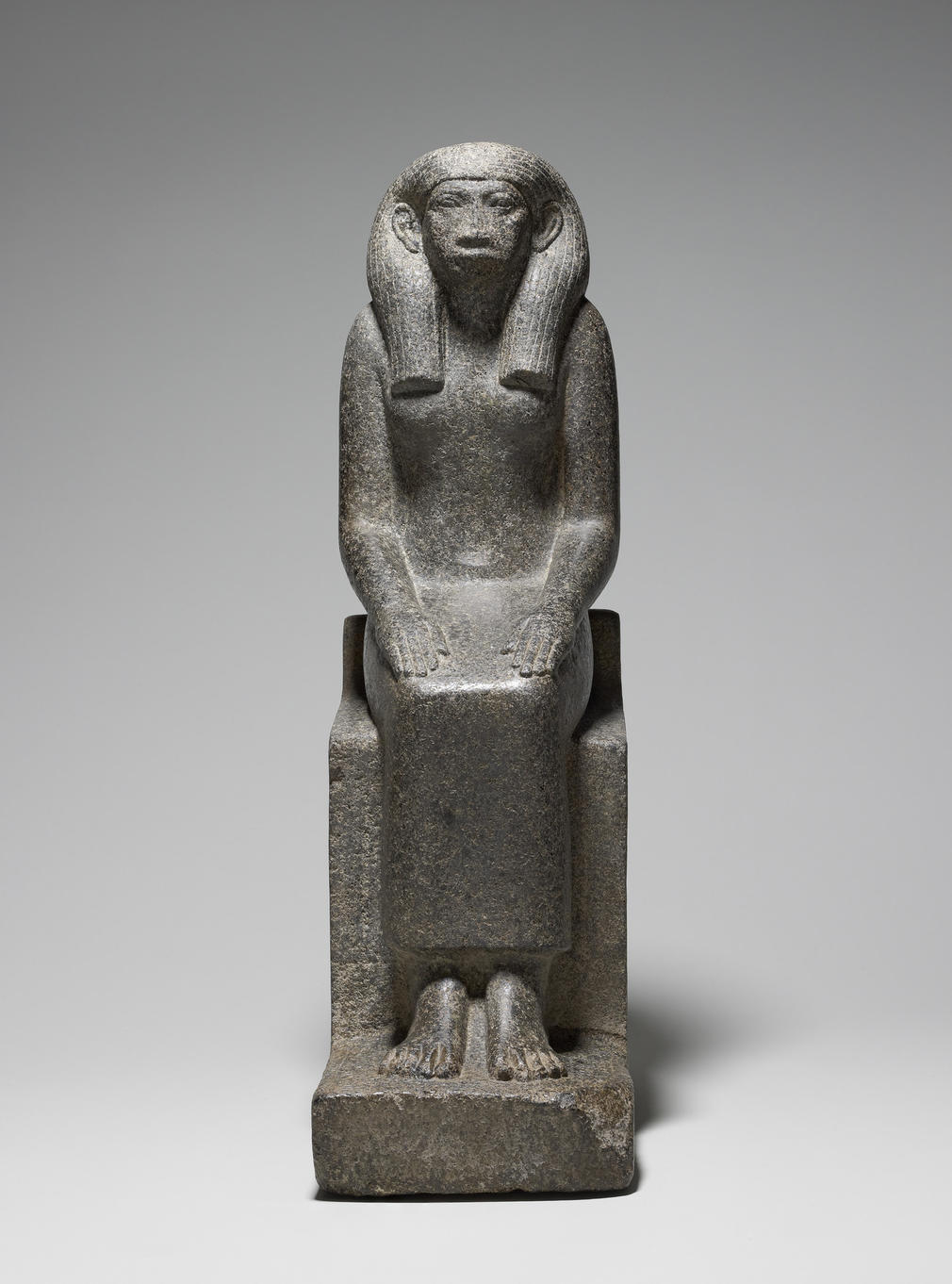 Black granite statue of Queen Senet, consort and mother of two as yet unidentified pharaohs of the XII Dynasty (c.1985–1785 BC). She is depicted seated on a throne with her hands resting on her thighs, palms down, fingers outstretched, and wearing a str