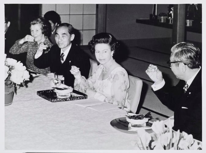 Queen Elizabeth II drinking Sake during dinner at a Japanese restaurant in Kyoto
