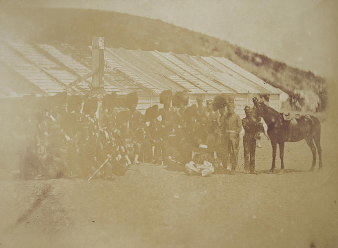 Highland Regiment grouped outside line of huts, with horse [taken from contents list]. [Crimean War photographs by Robertson]