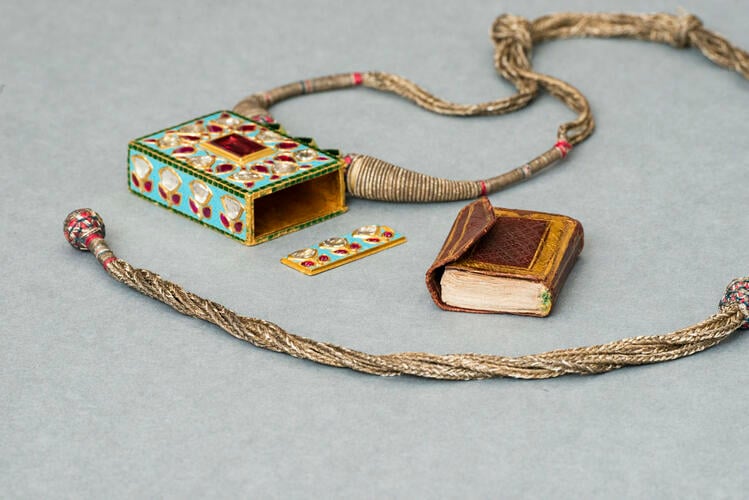 Amulet or necklace holding a miniature Quran