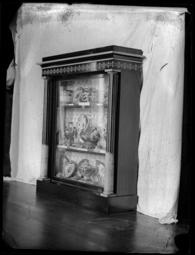 Glass plate negative showing a Marsh and Tatham ebony and ivory bookcase with porcelain, in the Grand Corridor, Windsor Castle Glass plate negative showing a Marsh and Tatham ebony and ivory bookcase with porcelain, in the Grand Corridor, Windsor Castle