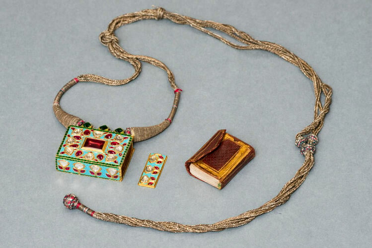 Amulet or necklace holding a miniature Quran