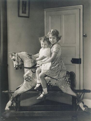 Princess Elizabeth and Princess Margaret riding a rocking horse at St Paul’s Walden Bury, August 1932