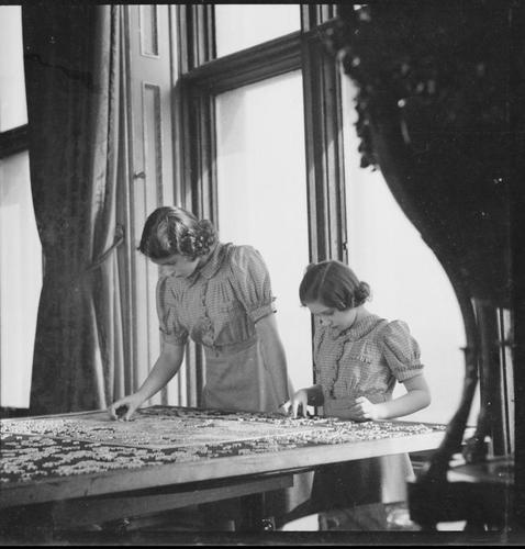 Princesses Elizabeth and Margaret working on a jigsaw, 1941