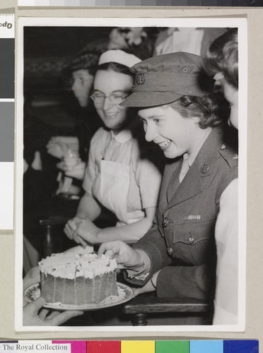 Princess Elizabeth accepting a piece of cake at a tea party at the Royal College of Nursing