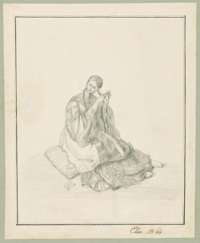 A seated woman braiding her hair
