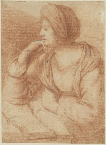 A woman wearing a turban and seated at a table A woman wearing a turban and seated at a table