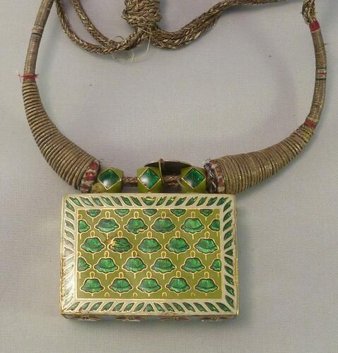 Amulet or necklace holding a miniature Quran