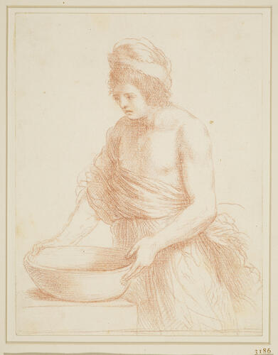 A youth holding a basin on a table