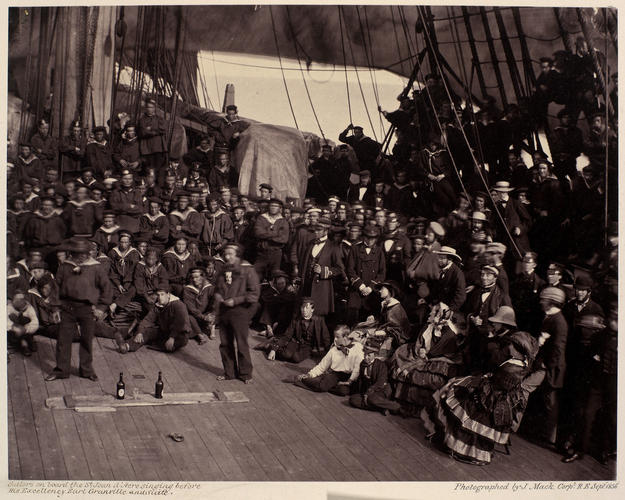 Sailors gathered on the deck of HMS St Jean d'Acre to sing to Lord Granville and his suite