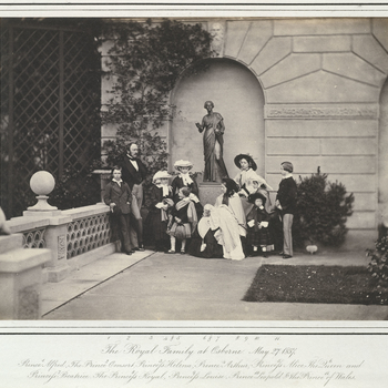 Photograph of The Royal Family on the terrace at Osborne. From left to right:  Prince Alfred, Prince Albert, Princess Helena, Princess Alice, Prince Arthur, Queen Victoria holding Princess Beatrice, Princess Royal, Princess Louise, Prince Leopol