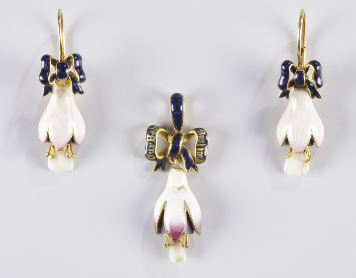 A pendant and a pair of gold mounted enamel earrings in the form of a fuscia flower set with milk teeth from Princess Beatrice (1857-1944), Queen Victoria's youngest child. These are suspended from an enamelled ribbon.
The work of setting the teeth in the